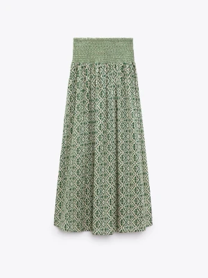 Grönmönstrad långkjol med smock - Säljer en långkjol med grön och vit grafisk mönstring och bred smock i midjan. Kjolen har ett luftigt fall och är perfekt för varma dagar. Tillverkad i mjukt bomullstyg som känns skönt mot huden. Enkel att styla med både toppar och stickade tröjor.