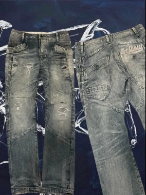 Grå slitna jeans från G-Star RAW🇺🇸 - Säljer ett par grå jeans från G-Star RAW med slitningar och detaljerade sömmar. Jeansen har flera fickor, dragkedja och en cool logga bak. Passar dig som gillar en streetwear-look och vill ha något unikt i garderoben. Passar 30/32. Skriv för mer info!