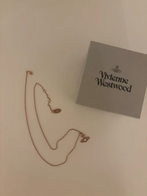 rosguldfärgat halsband Vivienne Westwood - Snyggt halsband från Vivienne Westwood i rosguldfärgad metall med det klassiska orb-hänget. 