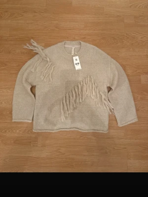 Beige stickad tröja med fransar - Beige knit sweater with unique fringe details. Soft and comfortable with a relaxed fit. Brand new with original tags still attached.  ✔ Size S ✔ Brand new with tags ✔ Soft & comfortable  #scandi #scandinavian #minimal #cleangirl #knitwear #beigeknit #everydaywear #capsulewardrobe #pinterestoutfit