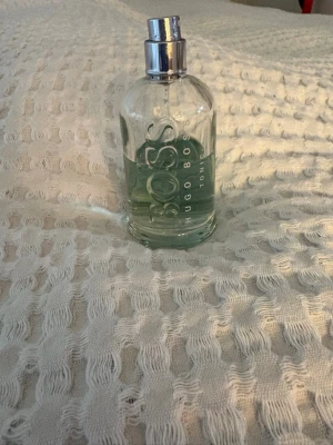 Hugo Boss Bottled Eau de Toilette - Klassisk parfym från Hugo Boss i en genomskinlig glasflaska med silverfärgad spraykork. Flaskan har rundad form och tydlig logga på framsidan. Doften är fräsch och maskulin, perfekt för dig som gillar stilrena och tidlösa parfymer.