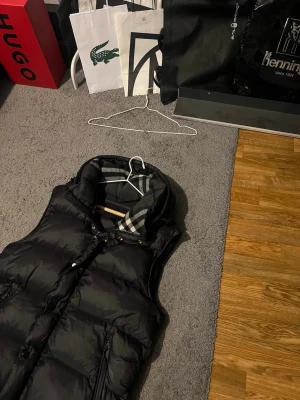 Burberry väst svart  - Svart burberry väst perfekt nu till hösten. Är egentligen en jacka men har inte armarna kvar därav e priset mycket billigare oxå och går även diskutera vid smidig affär🤝