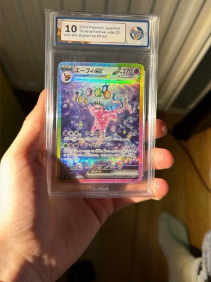 Ingen väst på bilderna - Bilderna visar ett Pokémonkort (Espeon ex Alt Art) i ett graderat plastfodral, inte en väst. Ingen väst kan beskrivas utifrån dessa bilder.