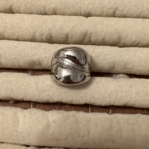 Silverfärgad ring - Säljer en snygg och stilren silverfärgad ring med en unik, böljande design. Perfekt för att ge en elegant touch till vilken outfit som helst. Passar både till vardags och fest!