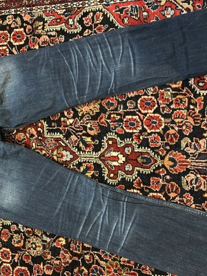 Blå raka jeans  - Snygga blå jeans med raka ben och klassisk femficksdesign. Jeansen har en tvättad look med slitningar och är tillverkade i mjukt bomullsjeansmaterial. Perfekta för en avslappnad och stilren outfit.