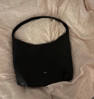 Black Shoulder Bag – ASOS – Minimalist Design - Stylish black shoulder bag from ASOS with a clean, minimalist design. Features a wide shoulder strap and zip closure on top for a sleek and practical look☺️  Made from smooth leather with a subtle logo on the front. Bought about a year ago but hardly used – in very good condition with no visible flaws☺️  Perfect everyday bag that works with any outfit💕💕