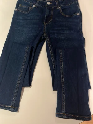 Levi's 510 mörkblå skinny jeans -  Aldrig använda. Säljer ett par Levi's 510 skinny jeans i mörkblå tvätt med klassiska kontrastsömmar och femficksmodell. Jeansen har en smal passform och är tillverkade i slitstarkt denim med Levi's ikoniska läderpatch bak i midjan.
