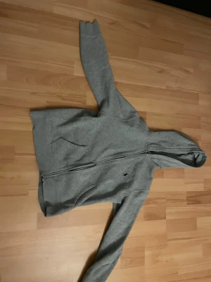 Ralph lauren zip hoodie - Grå Ralph lauren zip hoddie med en blå logga, tröjan är lätt att styla olika stiler med och sitter riktigt fint