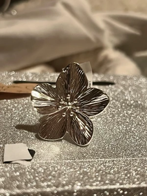 Silver blom ring - Hej! Fick två i julklapp, så säljer den ena 🤗 Ringen är från glitter och är i storlek M, 18 mm 💞 (ringen är silverfärgad, alltså inte äkta silver)