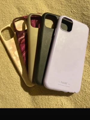 Paket med 5 mobilskal – iPhone 11 - Säljer ett paket med 5 mobilskal till iPhone 11. Olika färger & stilar – perfekt om du gillar att byta look ofta.  ✔ Passar iPhone 11 ✔ Normalt slitage, inga sprickor ✔ Skyddar kanter & kamera  Säljs i två paket: • Litet paket: 2 skal från Ideal of Sweden • Stort paket: resterande skal (bl.a. Holdit)  💰100 kr för hela paketet Vill du köpa endast ett paket? Skicka meddelande innan köp. Snabb frakt📦