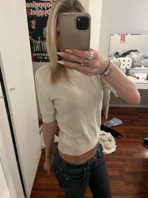 Vit  kortärmad topp i bomull - Säljer en stilren vit topp med korta ärmar och rund hals. Modellen är croppad och har en enkel, clean look som passar till mycket. Materialet känns mjukt och skönt mot huden. Perfekt att matcha med jeans eller kjol för en chill vibe.