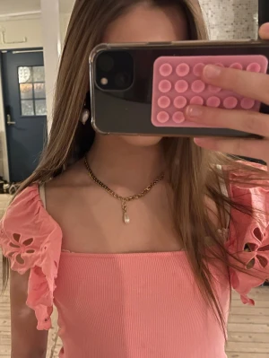 Rosa topp med volangärmar och broderi - Supersöt rosa topp med ribbad kropp och korta volangärmar i broderad bomull. Ärmarna har blommiga utskärningar som ger en extra detalj. Toppen är lite kortare och passar därför perfekt när det är varmt 💕💕