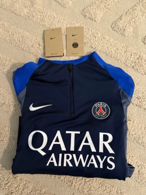 PSG x Nike långärmad träningströja - Mörkblå långärmad träningströja från Nike i samarbete med Paris Saint-Germain.  Perfekt för fotbollsträning elr gym. Tröjan är endast testad och köpt från PSG butik i Paris. Kom DM vid frågor o funderingar!