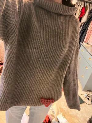 Beige/brun  ribbad polotröja  - Mysig beige polotröja med bred krage och ribbad struktur. Tröjan är stickad  och har en loose passform med långa ärmar. Perfekt för kyliga dagar och enkel att styla med jeans eller kjol. Storlek m men passar även s!