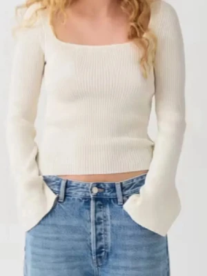 Vit ribbad långärmad topp - Säljer en stilren vit ribbad topp med lång ärm och fyrkantig ringning. Toppen är croppad och har en slim passform som sitter snyggt på kroppen. Perfekt att matcha med jeans eller kjol för en clean look.
