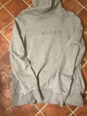 Tommy Hilfiger hoodie - Tjena, säljer nu min gråa Tommy Hilfiger hoodie i storlek Large. Hoodien är i väldigt bra skick, inga defekter och använd några enstaka gånger. Pris kan diskuteras 