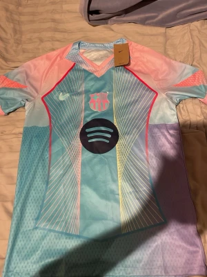 Barcelona tröja S - Bilderna visar en FC Barcelona Nike Dri-Fit matchtröja i pastellfärger med Spotify-logga och ett Nike märke. Tröjan har aldrig använts och är fräsch.