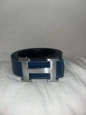 Läder bälte med silver spänne - Jag säljer ett helt nytt mörkblått läderbälte med silver spänne. Detta bälte är unikt eftersom att man kan ta vara på båda sidorna genom att bara vända om spännet(från blått till svart).