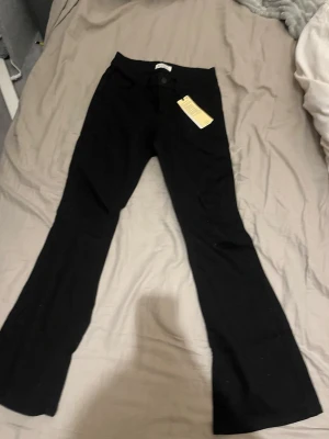 Svarta bootcut jeans från Lindex  - Säljer ett par svarta utsvängda jeans Regular waist. De är jättebra kvalete. Säljer eftersom inte kom till andvädning. I storlek 12-13 år 158