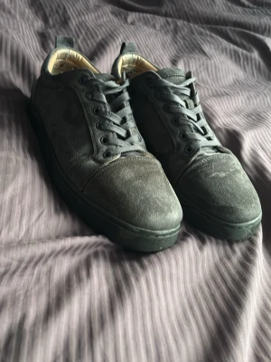 Gråa  mockasneakers från Louboutin - Säljer ett par rätt så slitna loubs. Kan tvättas innant vi fraktar. Har hål i hälen på båda skorna men inget man märker av. Priset kan diskuteras 