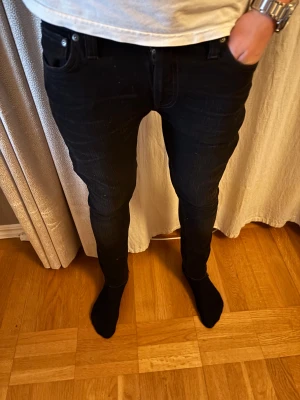 Svarta skinny jeans från Nudie Jeans - Svarta jeans från Nudie Jeans med slimfit passform! Modellen är 184cm men byxorna var dock för korta och små. |Skick 9/10| de defekter som synes på byxan längst ner och gjort i fabrik alltså ej från användning! Pris 299kr men inte hugget nypris ca 1600kr så passa på🤩🤩