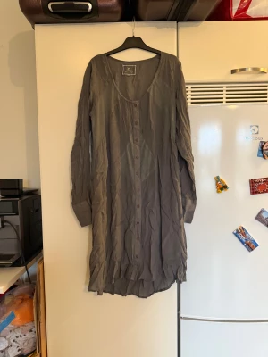 Fira klänning  - Säljer en superfin grå klänning i storlek M från märket Fira. Den ör fin men se anmärkning på sista bild. 