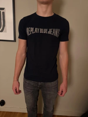 Svart Replay t-shirt med tryck - Tja! Nu säljer jag denna riktigt snygga vintage replay t-shirten i storlek M. Perfekt för dig som vill ha en väldigt klassisk stil.