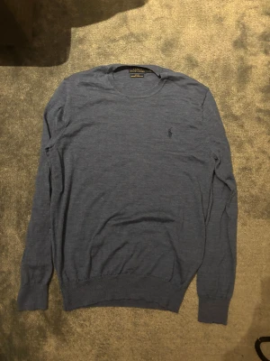 Polo Ralph lauren blå merinoullströja (strl M) - Snygg och klassisk tröja från polo Ralph lauren. Tröjan är 100% tvättbar merino ull. Mjukt och tunt material som funkar året runt. Färgen är blå med en broderad mörkblå logga! Nypris ligger på mellan 1300-1600kr. Hör av er vid intresse!