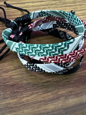 Färgglada tygarmband - Fyra coola tygarmband med justerbar svart snörning.  Materialet är mjukt tyg och snöret är i syntet. Storleken kan ändras genom att dra på ena snöret! 1 för 20kr, 2 för 30kr, hela settet för 40kr!