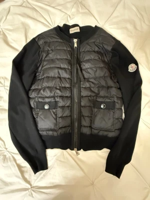 Svart Moncler Cardigan - Säljer min Moncler cardigan då den inte kommer till användning längre. Fick den från min kusin den för ungefär 2-3 år sedan. Passar perfekt under vår, sommar och höst!  Priset sänks vid snabb affär, kan mötas upp i gbg!❤️