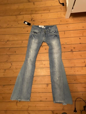 Lågmidjade bootcut jeans med slitningar - Säljer dessa lågmidjade jeans som är utsydda till bootcut och som har slitningar på benen. Har tyvärr ingen bild med de på då de är för små för mig. Jeansen är i bra skick och har lappen kvar. Midjemått 35 cm tvärs över midjan och innerbenslängd 78 cm💗💗