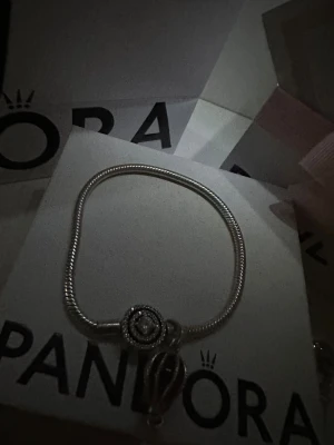 Silverfärgad Pandora armband med berlocker - Snygg Pandora silver armband med berlock på kostar 1800kr totalt, använd nästan 3 gånger!