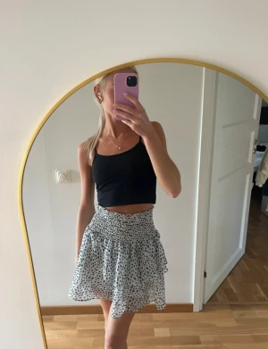 Prickig kortkjol  - Supersöt vit kortkjol med svart prickigt mönster & dubbel volang. Kjolen har smock i midjan. Säljer då den tyvärr inte kommer i användning av mig längre. Är ifrån Chelsea & i storlek XS🤍🖤