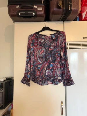 Odd molly blus  - Säljer en otroligt vacker blus med en bottenfärg i mörkblå. Den har ett superfint detaljerat mönster i bland annat rött, blått, svart och vitt. Från märket Odd Molly. Storlek 2 som enligt deras storleksguide motsvarar en M. Mer använd men fortfarande fint skick. 