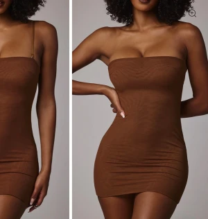 Brun kort under klänning från Oh Polly - Snygg brun under klänning från Oh Polly med justerbara smala axelband och draperad halsringning. Modellen är kort och figurnära. Materialet är mjukt och har en lätt glansig finish som ger en exklusiv känsla.