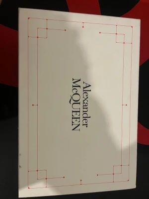 Alexander McQueen svarta sneakers - Säljer ett par ikoniska Alexander McQueen sneakers i svart skinn med vit häl och logga bak. Klassisk chunky sula och svarta skosnören. Grymt snygga och passar till allt för dig som vill ha en clean men ändå statement look. (KVITTO KVINNS)