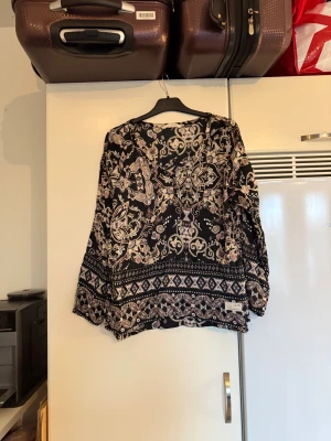 Odd molly blus  - Säljer en superfin blus som med en svart bottenfärg och även detaljer i bland annat beige, rosa och vitt. Från märket Odd Molly. Storlek 2 som enligt deras storleksguide motsvarar en M. Mycket fint skick, jag hittar inga synliga anmärkningar eller defekter. 