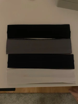 Svart, grå och vit trikåväst - Säljer 4st hårband!  I svart,grå, marinblå & vit. Aldrig använda. Funkar bra när du vill sminka dig eller bara få undan håret! Vet dock ej vart de är från💗