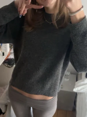 Mörkgrå stickad tröja - Superfin mörkgrå stickad tröja! Använd varsamt så inga tydliga tecken på användning. Lite nopprig men lätt att fixa. 