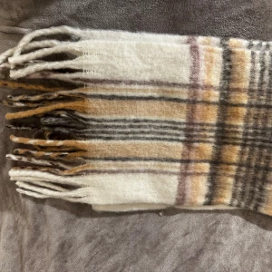 Rutig cashmere halsduk  - En rutig cashmere halsduk perfekt för höst-vintern. Gjord med mjuk cashmere vilket gör den mycket varm. Halsduken är 250cm x 38cm. Aldrig andvänd i perfekt skick.