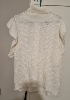 Stickat tröja.  - Fina stickat vit tröja med volanger.