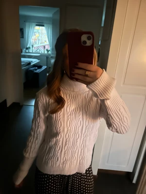Vit polotröja från Hailys - Säljer en vit polotröja från Hailys i storlek S. Tröjan har ett snyggt kabelstickat mönster och ribbade muddar vid hals, ärmslut och nederkant. Perfekt för dig som gillar klassisk stil med en modern twist.