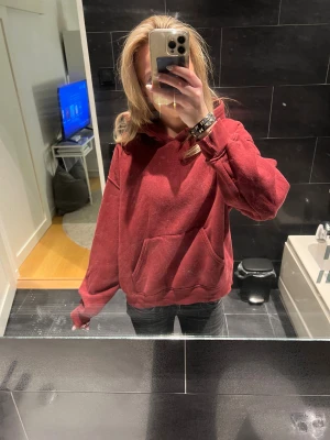 Mörkröd hoodie med huva - Enkel och snygg mörkröd hoodie med huva och stor magficka. Modellen är loose fit med ribbade muddar vid ärmslut och nederkant. Perfekt för chill dagar och passar till det mesta. Materialet känns mjukt och skönt mot huden. Storlek S men passar även Xs bara att skriva vid frågor!!