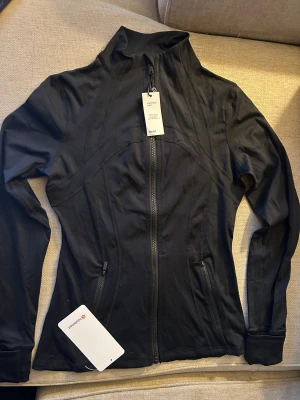 Svart träningsjacka från Lululemon - Jättefin jacka från Lululemons tidigare kollektion. Köpt på Vinted men passade inte dottern. Som define i modellen men i lite tunnare material. 