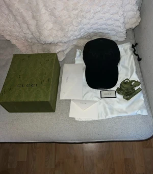 Gucci keps  - Säljer en svart keps från Gucci med klassiskt GG-mönster i samma ton över hela kepsen. Justerbar rem baktill i svart läder, Kommer med originalkartong, dustbag och grönt Gucci-band. 