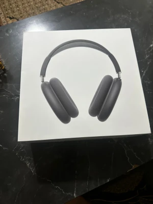 AirPods Max - Apple AirPods Max i svart färg, over-ear trådlösa hörlurar med aktiv brusreducering. Komplett med originalförpackning och skyddsfodral. Hörlurarna ser ut att vara i mycket gott skick utan synliga repor eller skador.