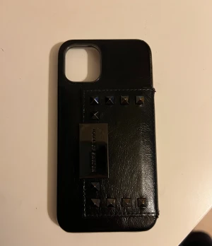 Mobilskal med nitar  - Mobilskal för iPhone 11 Pro. Har använt litegrann och den är lite sliten längst ut på nitarna man kan se de på sista bilden. Har även boxen man fick den i som man får med.🥰🥰Nypris 699kr