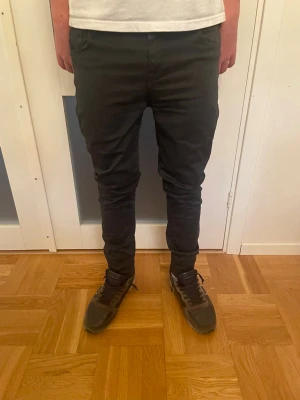 Replay anbass jeans  - Dessa svarta Replay-byxor erbjuder en modern och stilren passform som passar både vardag och mer uppklädda tillfällen. Materialet är mjukt och bekvämt, vilket gör dem enkla att bära under hela dagen. En diskret design tillsammans med hög kvalitet gör dem till ett pålitligt och tidlöst tillskott i garderoben. Ett utmärkt val för dig som söker både komfort och stil.