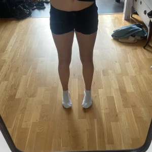 Svarta jeansshorts - Svarta jeansshorts från Lindex med råa kanter och klassisk femficksdesign. De har normal passform och low waist , perfekt för en avslappnad stil. Materialet är jeans och färgen är helsvart, vilket gör dem enkla att matcha med allt.