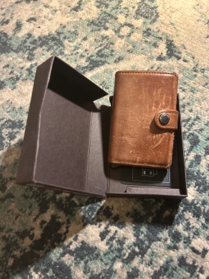 En plånbok från Secrid - Secrid läderplånbok för unisex. Tillverkad i lädermaterial med flera fack för kort och kontanter. Designad för att organisera och förvara personliga tillhörigheter på ett praktiskt sätt.